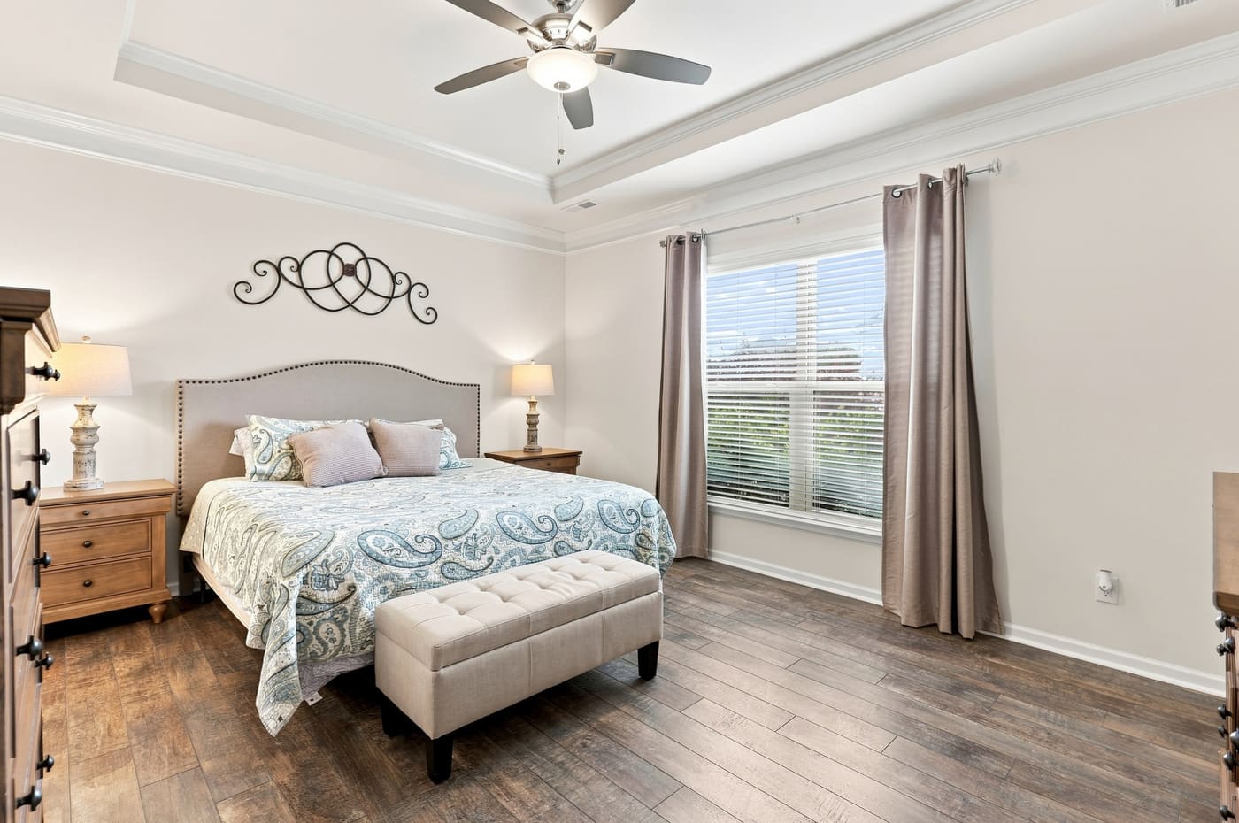 The primary bedroom with a window to the rear yard and a tray ceiling.